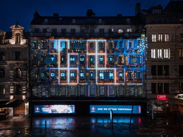 Brightly outlined windows turn a five-storey Stockholm facade into a glowing arcade game at night.